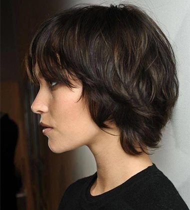 side profile of a woman in black sweater with a shaggy cut