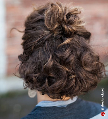 back profile of a woman in curly half up half down hair