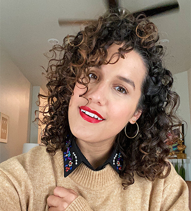 Woman with brown sweater and curly hair