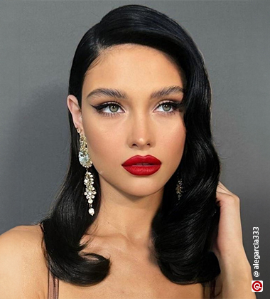 woman wearing a red lipstick and long earrings with side swept hair