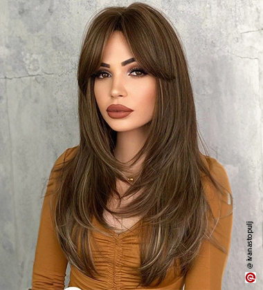 woman with a full face of makeup and brown lipstick with long hair