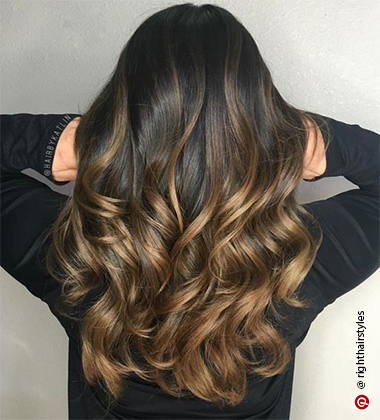 back profile of a woman with golden highlights in a black shirt